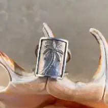 Bague en argent martelé, gravée d’un palmier et poinçonnée du sigle « 925 ».